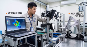 Structural FEA simulation and DIC measurement correlation setup in a mechanical laboratory, demonstrating the validation of digital twin models against real-world physical testing.